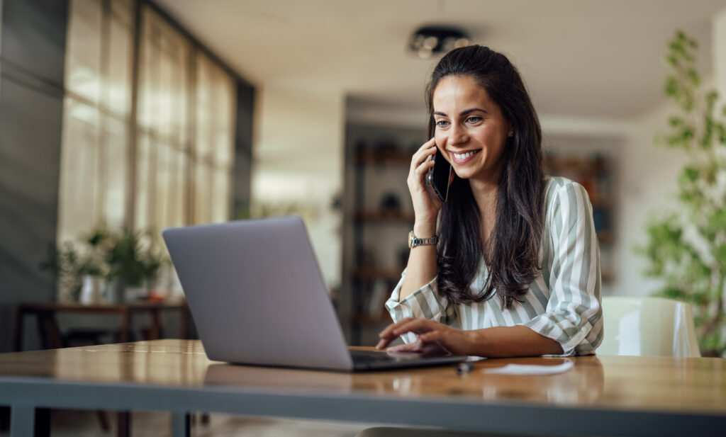 Girl on laptop using phone for Google Local Service Ad